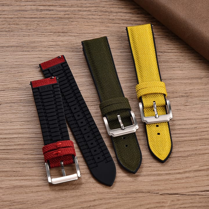 The Spinnaker in Red turned over to show its textured black rubber underside, next to the Olive and Yellow bands