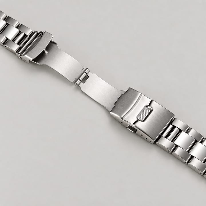 The Reef's fold-over clasp opened, showing the flip-lock cover and push button