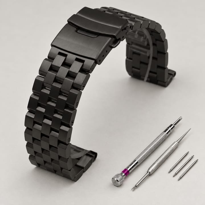 The Anvil in black with screw links, shown with its spring bar tool and screwdriver