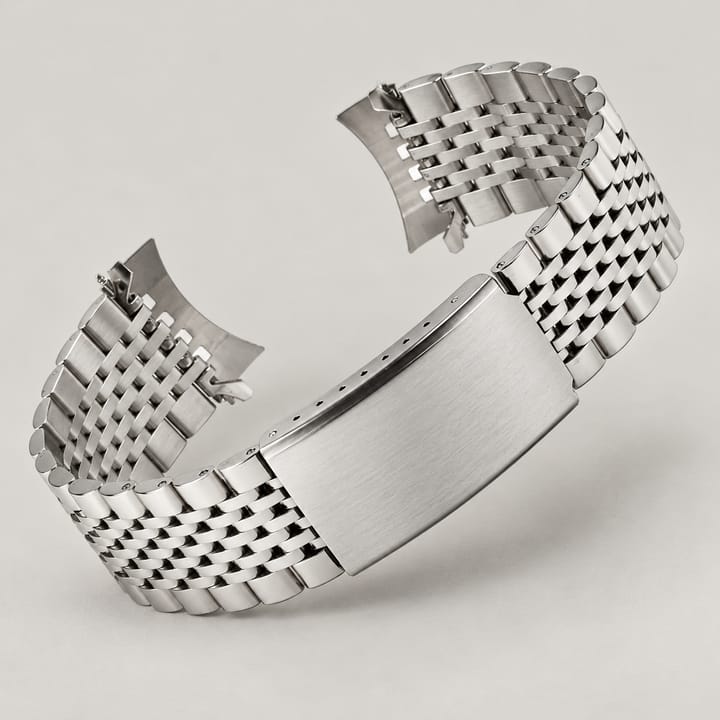 The Bead bracelet curled on its side, showing curved end links and the fold-over clasp