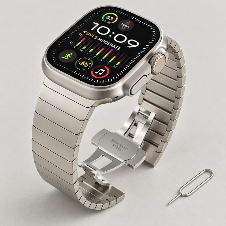 The Summit steel link band for Apple Watch in Starlight, a warm light gray, with the butterfly clasp open